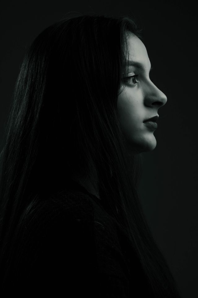 Side profile monochrome portrait of a woman with long hair, artistic mood.